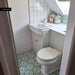 Traditional cloakroom featuring Medina Soft Green Moroccan style hexagon floor tiles, paired with white square wall tiles, a classic white vanity unit, a chrome tap and soft sage green accents for a bright, characterful space.