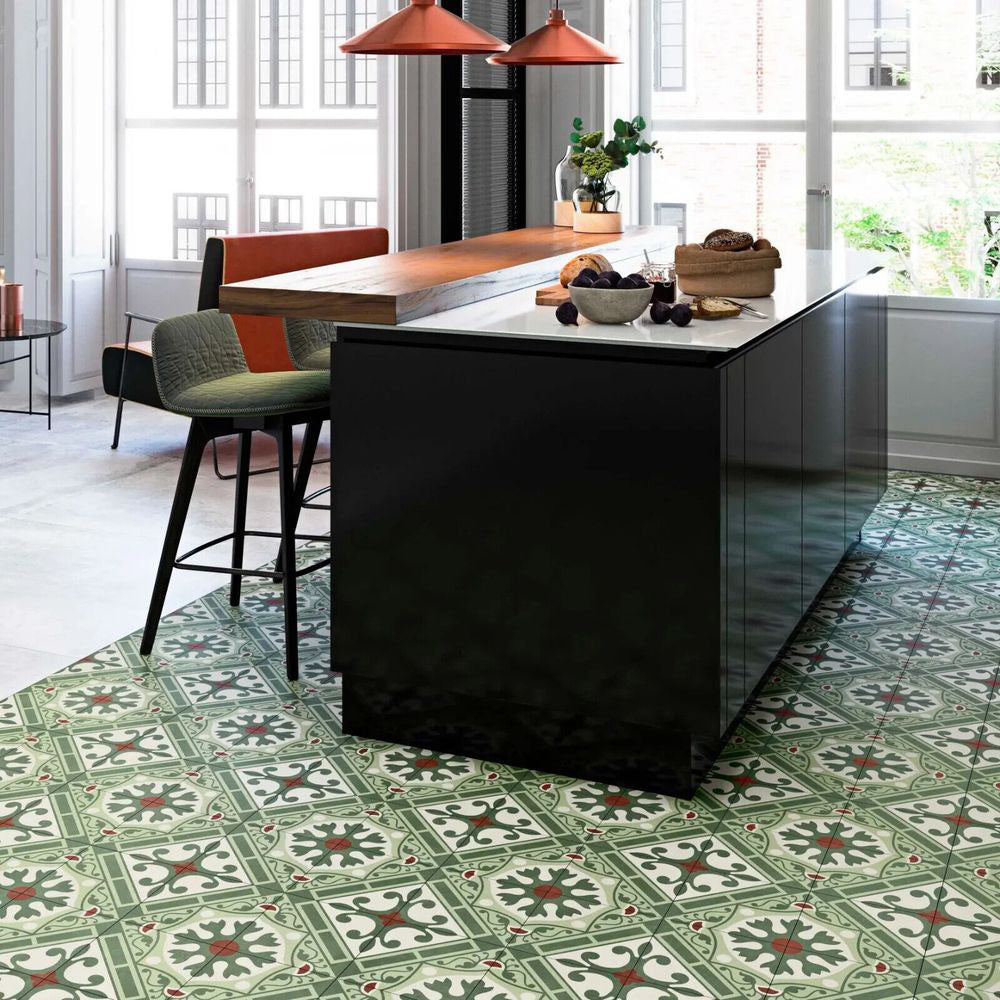 Contemporary kitchen featuring Mediterraneo Corfu 2cm patterned outdoor slabs 50 × 100cm, showcasing a decorative Mediterranean-inspired pattern in green, cream, and terracotta tones, paired with sleek black cabinetry and warm wood accents.