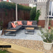Outdoor seating area featuring Mediterraneo Olbia 2cm Patterned Outdoor Slabs 50x100cm, showcasing a decorative Mediterranean-style pattern in soft blue, green and terracotta tones, paired with contemporary garden furniture, gravel borders and a pergola-covered terrace.
