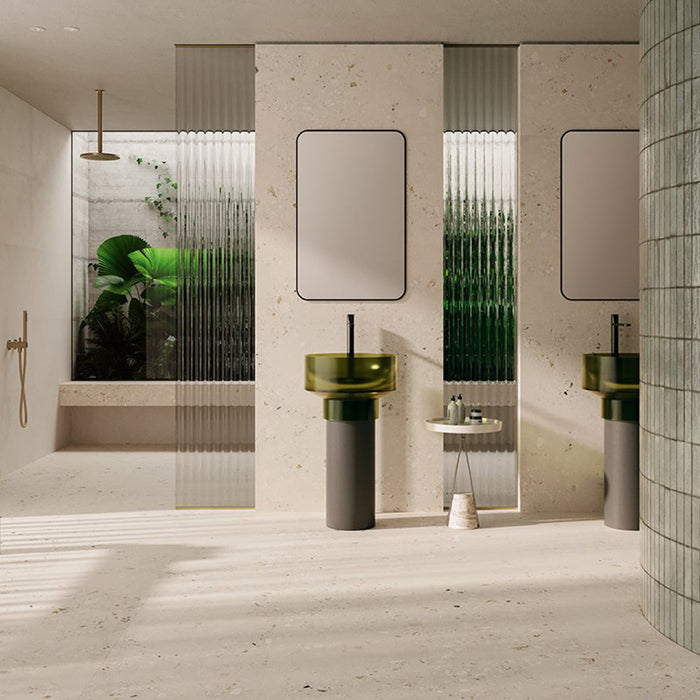 Contemporary bathroom featuring Melange Light Cosmo Stone wall and floor tiles 60 × 120cm, showcasing soft ivory stone-effect tones with subtle aggregate detailing, paired with green glass basins, fluted glass panels, and minimalist fittings.