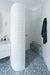 Minimalist bathroom featuring Melody POP Terrazzo Blue 60 × 60cm terrazzo-effect porcelain tiles, showcasing soft white stone fragments across a muted blue base, paired with crisp white surfaces, black fixtures, and clean contemporary styling.