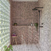 Walk-in shower featuring Melody POP Terrazzo Pink 60cm x 120cm terrazzo effect wall and floor tiles, with pink and black detailing, black shower fittings and a glass block wall.