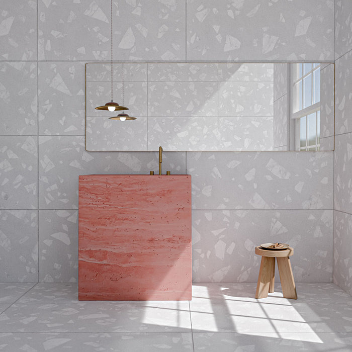 Bathroom featuring Melody ROCK Terrazzo White 60cm x 120cm wall and floor tiles with a large-scale terrazzo effect, paired with a statement pink vanity, brass fixtures and warm wood details.
