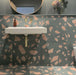Bathroom featuring Melody ROCK Terrazzo Green 60 × 60cm terrazzo-effect porcelain wall and floor tiles, combining oversized blush pink stone fragments with a deep green base, paired with brass fittings and dark painted walls for a bold contemporary interior.