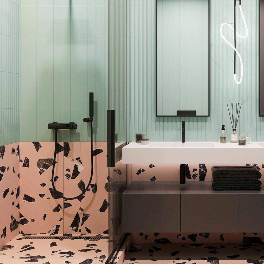 Contemporary bathroom featuring Melody Rock Pink 60cm x 120cm terrazzo effect porcelain wall and floor tiles, paired with mint green fluted wall tiles, black brassware, floating vanity and a walk-in shower.