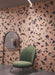 Contemporary interior featuring Melody ROCK Terrazzo Pink 60 × 60cm porcelain wall tiles, designed with oversized black marble-effect fragments set against a soft pink background, creating a bold terrazzo-inspired statement paired with modern furniture and deep charcoal flooring.