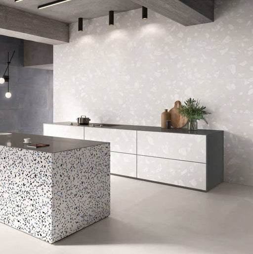 Contemporary kitchen featuring Melody ROCK Terrazzo White 60 × 120cm terrazzo-effect porcelain wall tiles, showcasing oversized white stone fragments on a soft pale base, paired with minimalist cabinetry, concrete finishes, and a statement terrazzo island for a modern architectural look.