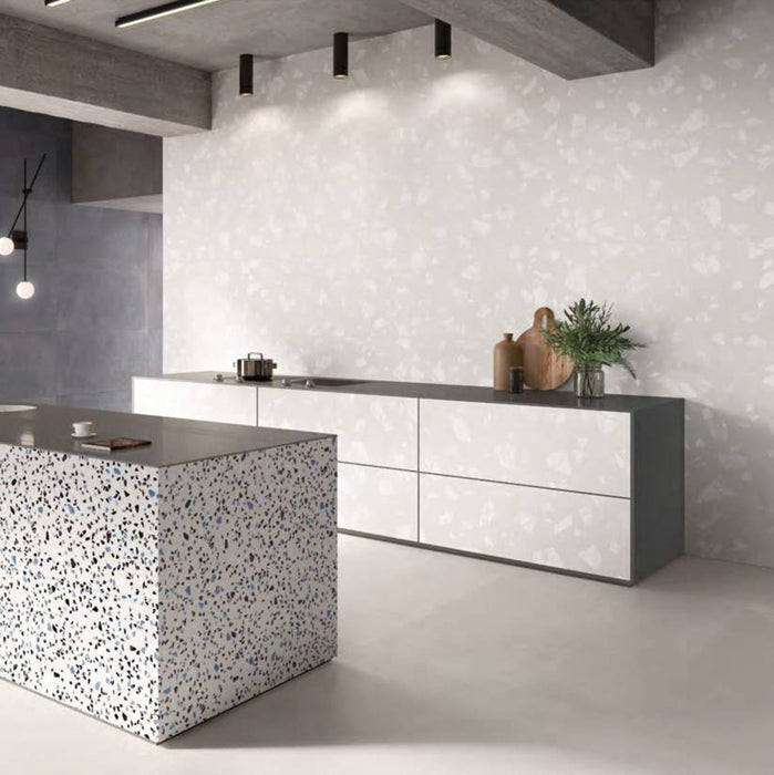 Contemporary kitchen featuring Melody ROCK Terrazzo White 60 × 120cm terrazzo-effect porcelain wall tiles, showcasing oversized white stone fragments on a soft pale base, paired with minimalist cabinetry, concrete finishes, and a statement terrazzo island for a modern architectural look.