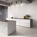 Contemporary kitchen featuring Melody ROCK Terrazzo White 60 × 120cm terrazzo-effect porcelain wall tiles, showcasing oversized white stone fragments on a soft pale base, paired with minimalist cabinetry, concrete finishes, and a statement terrazzo island for a modern architectural look.