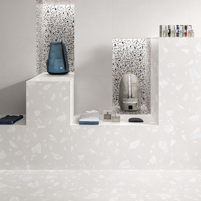 Retail-inspired interior featuring Melody ROCK Terrazzo White 60 × 60cm terrazzo-effect porcelain wall and floor tiles, showcasing oversized marble-inspired fragments on a crisp white base, paired with minimalist display shelving and monochrome styling for a clean contemporary aesthetic.