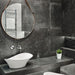 Lifestyle image of Monzo Stone Nite 60x60cm dark stone-effect porcelain wall and floor tiles in rich charcoal tones, featuring subtle veining and natural stone-inspired texture, styled within a modern bathroom with sleek black accents and contemporary fittings.