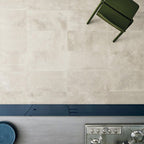 Kitchen featuring Monzo Stone Sand 30x60cm stone-effect porcelain wall tiles in warm beige tones, styled with dark blue kitchen cabinetry, stainless steel appliances, and subtle natural-style veining for a contemporary interior look.