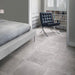Bedroom featuring Monzo Stone Titanium 60x60cm stone-effect porcelain floor tiles in soft grey tones, styled with modern furniture, neutral interiors, black leather seating, and subtle natural-style veining.
