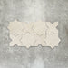 Close-up of Muscat Avorio Rocks Star and Cross wall and floor tiles arranged in a repeating geometric pattern, showcasing soft ivory tones, subtle speckled detailing and a textured stone-effect finish.
