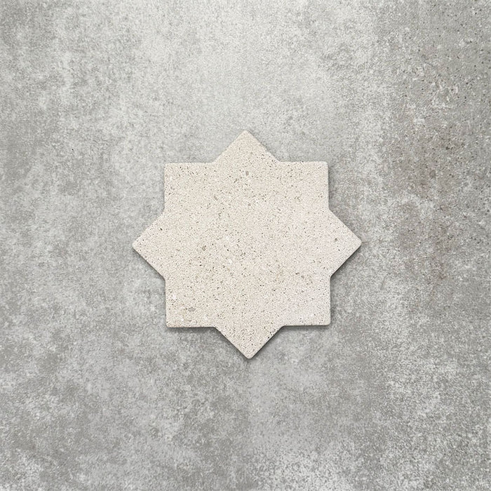 Close-up of Muscat Avorio Rocks Star wall and floor tile, showcasing an eight-point geometric star shape, soft ivory tones, subtle speckled detailing and a textured stone-effect finish.