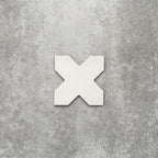 Close-up of Muscat Bone Cross Moroccan-style porcelain wall and floor tile, showcasing a distinctive geometric cross shape, soft bone white tone and smooth matt finish.