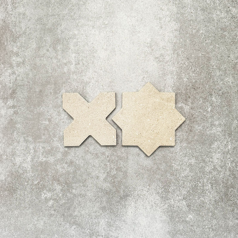Close-up of Muscat Sands Star and Cross wall and floor tiles, showcasing coordinating geometric shapes, warm sandy beige tones, subtle speckled detailing and a matt finish.
