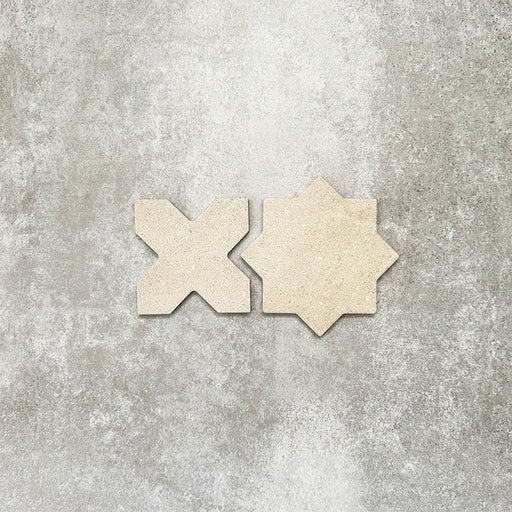 Close-up of Muscat Sands Star and Cross wall and floor tiles, showcasing coordinating geometric shapes, warm sandy beige tones, subtle speckled detailing and a matt finish.