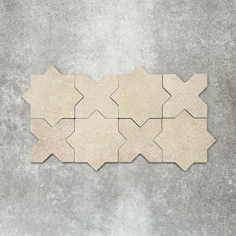 Close-up of Muscat Sands Star and Cross wall and floor tiles arranged in a repeating geometric pattern, showcasing warm sandy beige tones, subtle speckled detailing and a matt finish.