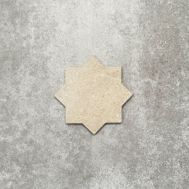 Close-up of Muscat Sands Star wall and floor tile, showcasing an eight-point geometric star shape, warm sandy beige tones, subtle speckled detailing and a matt finish.