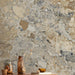 Interior featuring Museo Warm Stone Matt 60x120cm porcelain tiles, showcasing a bold marble effect design with warm beige, ivory and grey stone fragments, styled with natural wood surfaces and contemporary decorative accessories.