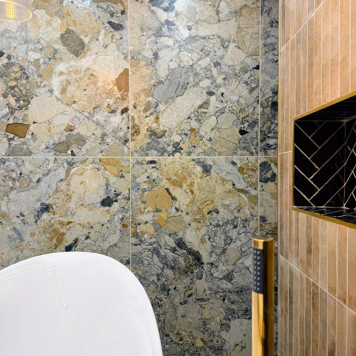 Bathroom featuring Museo Warm Stone Matt 60x120cm porcelain wall tiles, showcasing a dramatic marble effect design in warm beige, ivory and grey tones, paired with a freestanding bath, brass fittings and textured feature wall tiles.