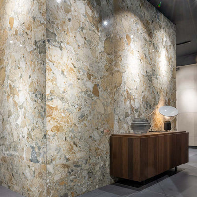 Interior featuring Museo Warm Stone Polished 60x120cm porcelain tiles, showcasing a striking marble effect design with warm beige, grey and ivory tones, paired with dark wood furniture and contemporary decorative lighting.