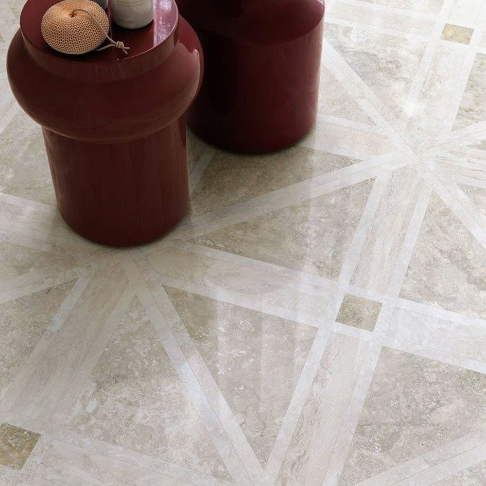 Close-up of Nucetto Travertine Decor 60x60cm wall and floor tiles, showcasing a geometric travertine effect pattern in warm neutral tones, styled with contemporary burgundy side tables for an elegant, modern finish.