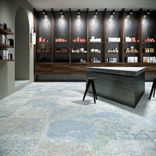 Interior featuring Boho Ocean Blue 60 × 60cm patterned floor tiles, blending soft blue and muted tones with a worn, decorative effect. Ideal for adding character to contemporary spaces such as retail interiors, kitchens, or open-plan living areas.