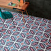 Office interior featuring London Streets Conduit Street 20x20cm Victorian Moroccan style floor tiles, styled with a wooden desk, green chair and dark wall tiles, showcasing a bold pink, teal and white patterned floor design.