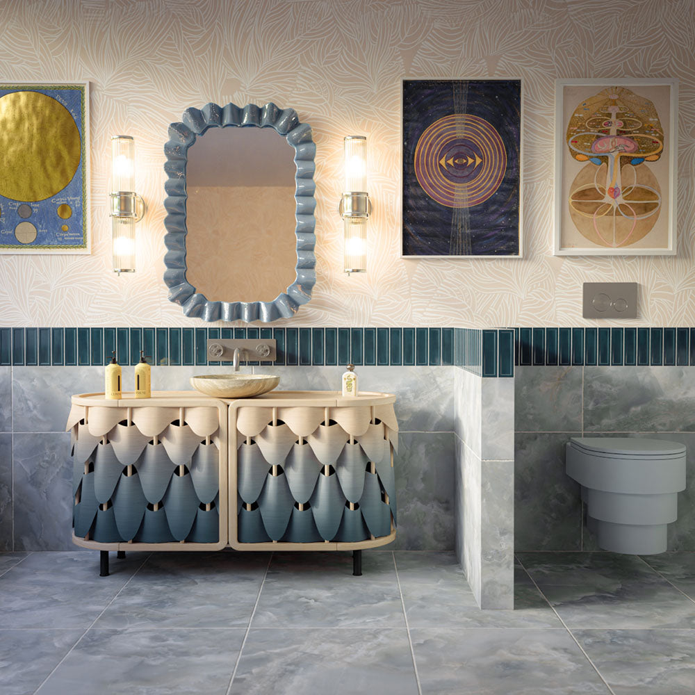 Contemporary bathroom featuring Osaka Blue Decor handmade style gloss wall tiles in 6.5cm x 20cm. Deep blue Moroccan style brick tiles create a striking feature border alongside blue onyx effect porcelain tiles, a statement vanity, bold artwork, and brass accents.