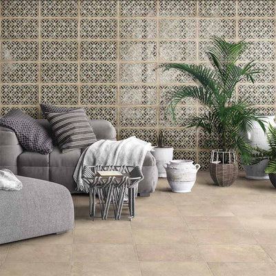 Living room featuring Ourika Emerald Green Moroccan style decorative porcelain wall tiles, showcasing an intricate geometric floral pattern in soft emerald green, beige and cream tones, paired with stone effect floor tiles, natural planting and relaxed contemporary furnishings for a warm, Mediterranean-inspired interior.