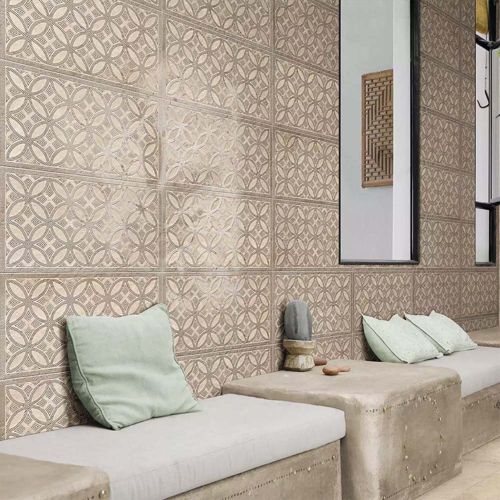 Bathroom featuring Ourika Sandy Beach Moroccan style decorative porcelain wall tiles, showcasing an intricate geometric floral pattern in soft sand, taupe and warm beige tones with a gently aged finish, paired with built-in concrete seating, pale green cushions, black framed mirrors and natural textures for a calm, contemporary Moroccan-inspired interior.