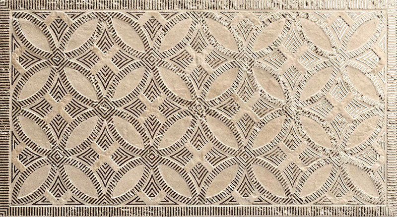 Close-up of Ourika Sandy Beach Moroccan style decorative porcelain wall tile, featuring an intricate carved geometric floral pattern in soft sandy beige and taupe tones with textured engraved detailing and a gently aged finish, perfect for creating statement bathroom walls, kitchen splashbacks and feature walls with timeless Moroccan-inspired character.