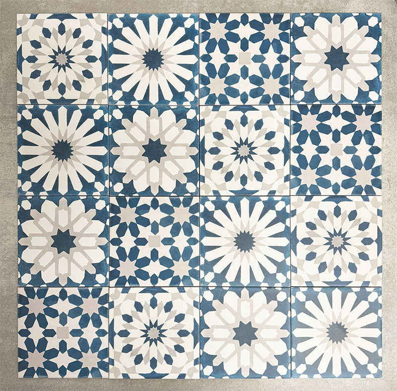 Souk Blue A 20×20cm Moroccan-style porcelain patchwork tiles featuring mixed blue, white and grey geometric patterns.