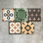 Cuba Patchwork Moroccan-style porcelain tiles in a 20×20cm square format, arranged in a mixed patchwork layout featuring a variety of geometric, floral and traditional motifs in earthy, green, blue and terracotta tones, highlighting the tile’s eclectic, encaustic-style design and rich visual texture.