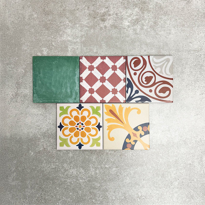 Fayrouz Mini Patchwork 15×15cm Moroccan-style porcelain tiles displayed as a mixed patchwork layout, showcasing a vibrant collection of geometric and floral designs in green, blue, pink, mustard, terracotta and neutral tones.