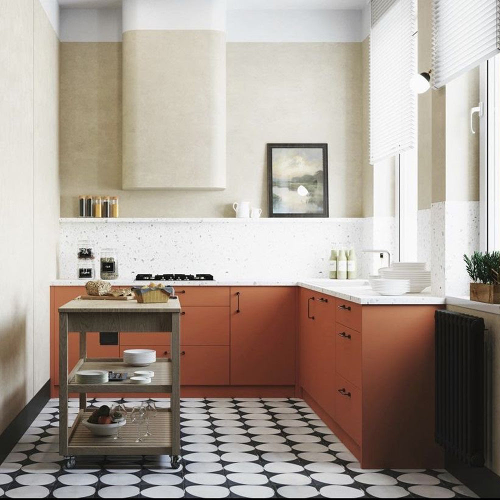Kitchen featuring Pebbles Black 20x20cm Moroccan-style patterned floor tiles in black and white tones, styled with terracotta cabinetry, terrazzo-effect worktops, warm neutral walls, and contemporary interiors.