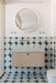 Modern bathroom featuring Pebbles Blue Moroccan style patterned wall and floor tiles in 20cm x 20cm. Bold blue and white geometric circles create a playful statement around a minimalist wood vanity, round mirror and crisp white bathroom fittings.
