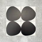 Pebbles Reversed Black 20x20cm porcelain Moroccan-style tiles featuring bold abstract black shapes on a soft white background, designed to create striking statement walls and contemporary patterned interiors.
