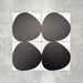 Pebbles Reversed Black 20x20cm porcelain Moroccan-style tiles featuring bold abstract black shapes on a soft white background, designed to create striking statement walls and contemporary patterned interiors.