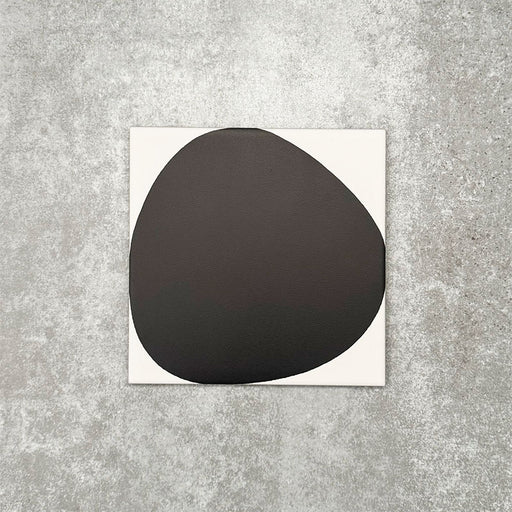 Pebbles Reversed Black 20x20cm porcelain Moroccan-style tiles featuring bold abstract black shapes on a soft white background, designed to create striking statement walls and contemporary patterned interiors.