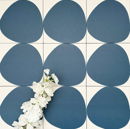 Pebbles Reversed Blue 20x20cm porcelain Moroccan-style tiles featuring bold organic blue shapes on a soft white background, designed to create playful statement walls and contemporary patterned interiors.