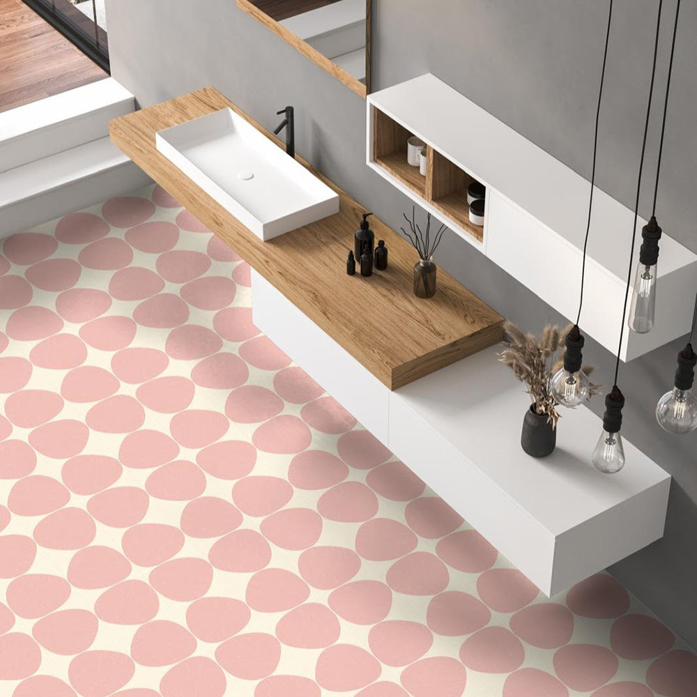 Bathroom featuring Pebbles Reversed Pink 20x20cm porcelain Moroccan-style floor tiles with soft blush abstract patterning, paired with wood accents, floating white cabinetry, and minimalist contemporary styling.