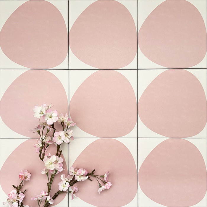 Pebbles Reversed Pink 20x20cm porcelain Moroccan-style tiles featuring soft blush abstract shapes on a warm white background, designed to create playful statement walls and contemporary patterned interiors.