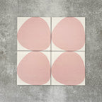 Pebbles Reversed Pink 20x20cm porcelain Moroccan-style tiles featuring soft blush abstract shapes on a warm white background, designed to create playful statement walls and contemporary patterned interiors.