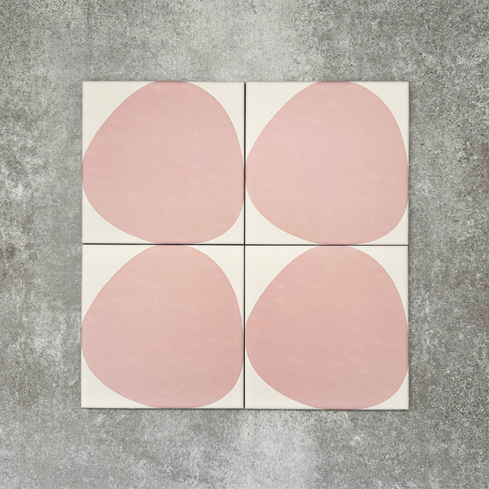 Pebbles Reversed Pink 20x20cm porcelain Moroccan-style tiles featuring soft blush abstract shapes on a warm white background, designed to create playful statement walls and contemporary patterned interiors.