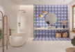 Bathroom featuring Peniscola Blue and Yellow patterned wall and floor tiles, showcasing a bold Mediterranean-inspired floral geometric design in vibrant cobalt blue, warm yellow and crisp white tones, paired with a floating stone vanity, round mirror, woven pendant lights, natural baskets and soft neutral finishes for a bright, characterful interior.