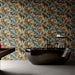 Bathroom featuring Plant Life Dark Decor 60x120cm botanical-style wall tiles, showcasing an oversized tropical leaf design in deep green, bronze and neutral tones, paired with a freestanding black bath, black fittings and large grey floor tiles.