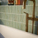Bathroom featuring Pottery Decor Agave Green 12.5x25cm wall tiles, styled within an arched alcove around a freestanding bath with brass fixtures, striped tile detailing, and soft Mediterranean-inspired tones.
